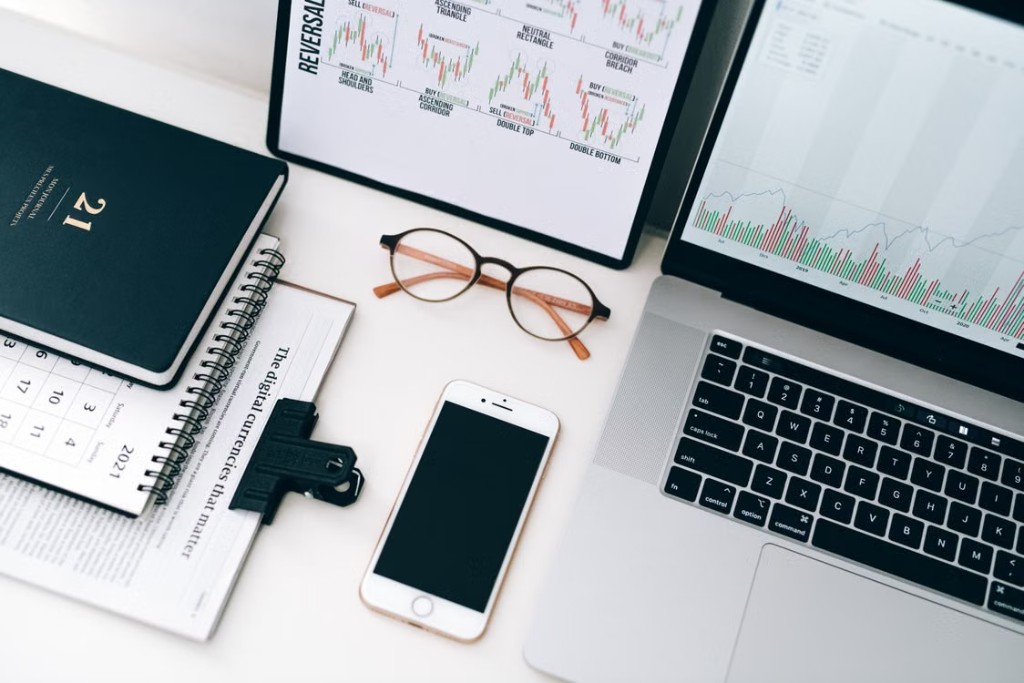 Desk setup with marketing charts on screens and a phone